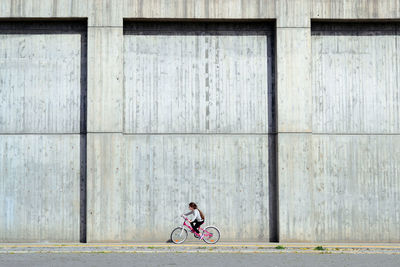 Full length of girl riding bicycle in city