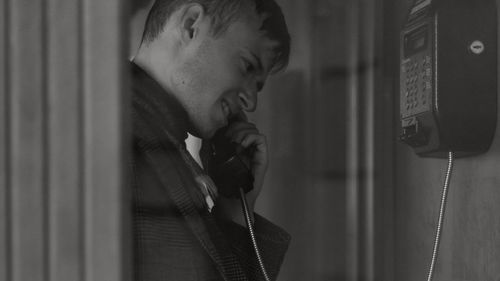 Portrait of young man using mobile phone at home