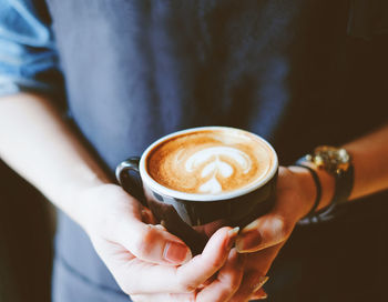 Midsection of woman holding coffee cup