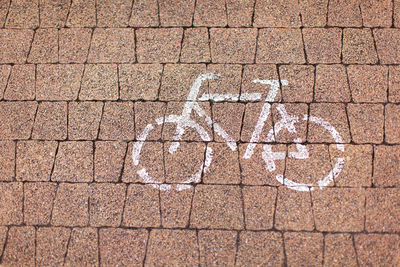 Road sign bicycle path painted in white on a cobblestone road. concept urban environment