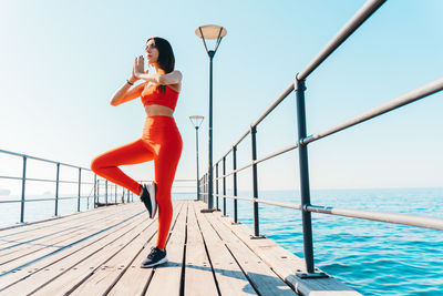 Female athlete meditating on pier