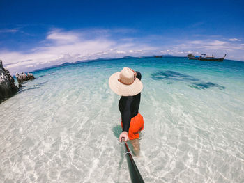 Rear view of man on beach against sky