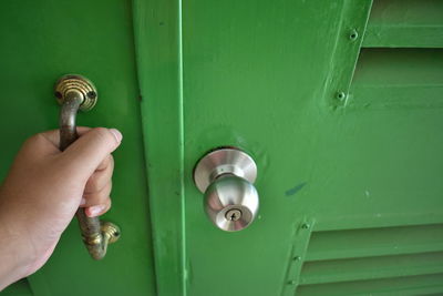 Human hand holding metal door