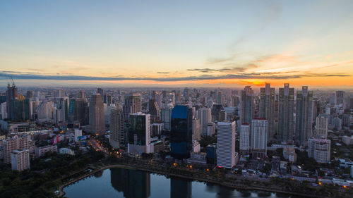 Aerial view of city buildings against sky during sunset