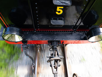 Close-up of yellow number five 5 on machine part 