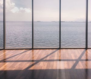 Sea against sky seen through glass window