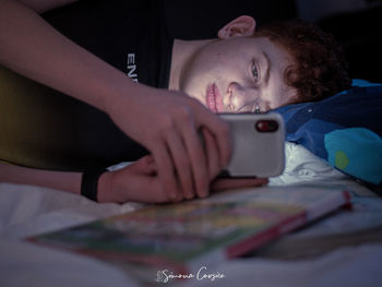 Portrait of boy resting on bed