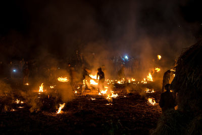 People watching burning fire at night