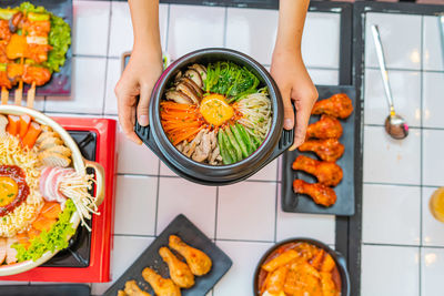 High angle view of woman holding food on table