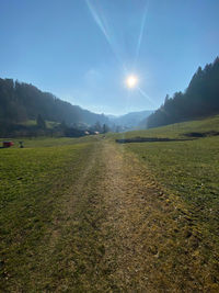 Scenic view of landscape against bright sun