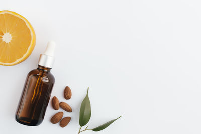 Orange essential oil in glass bottle with green leaf. cosmetic concept on white background