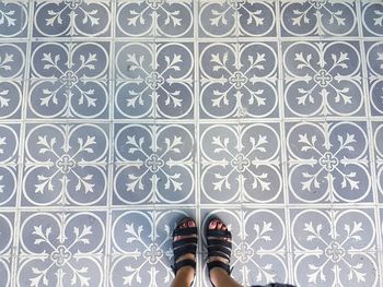 Low section of woman standing on tiled floor