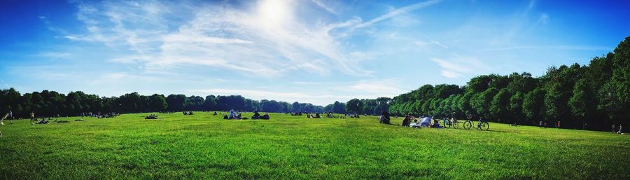 Panoramic view of people on field against sky