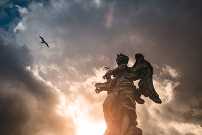 Low angle view of statue against cloudy sky