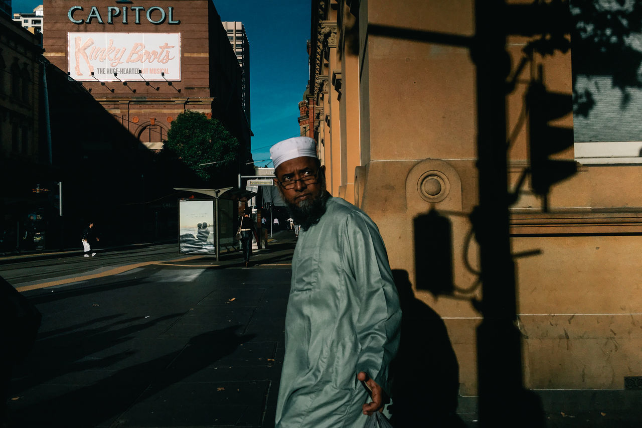 FULL LENGTH PORTRAIT OF MAN STANDING ON STREET