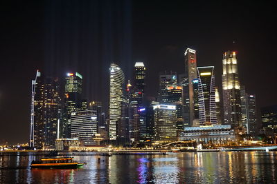 Illuminated cityscape against sky at night