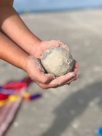 Close-up of hand holding sand on beach