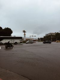 Cars on street in city against sky