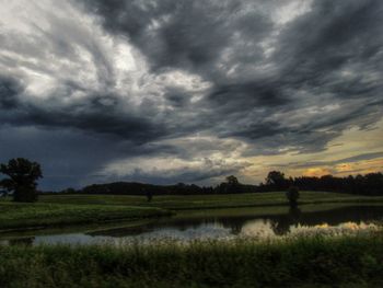 Scenic view of field against cloudy sky