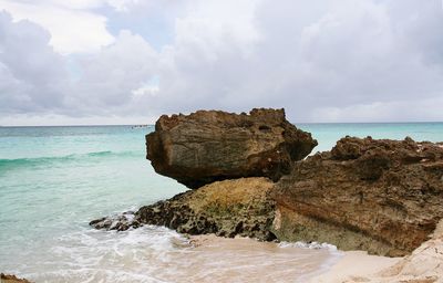 Rocks on sea shore against sky