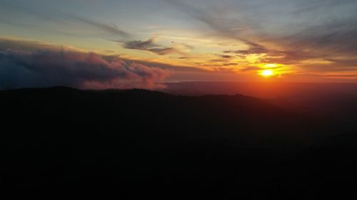 Scenic view of silhouette mountains against sky during sunset