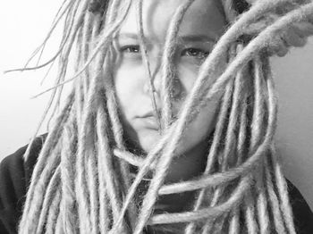 Close-up portrait of young woman against white background