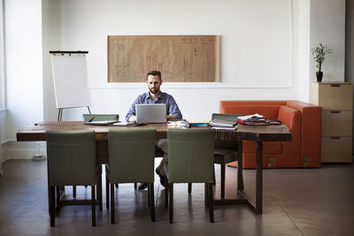 Man using laptop computer while sitting at desk in office