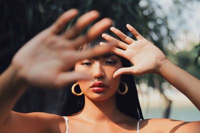 Portrait of young woman gesturing standing outdoors