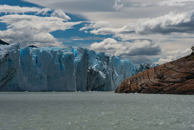 Panoramic view of sea and snowcapped mountains against sky