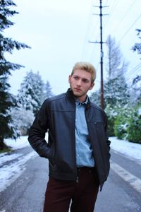 Young man standing on road during winter