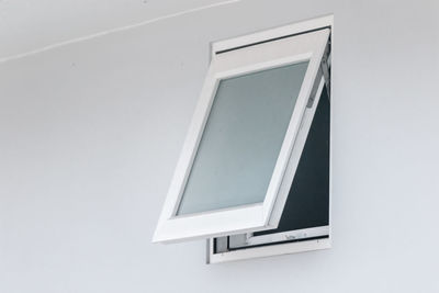 Low angle view of window on white wall