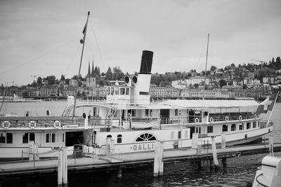 Boats moored in harbor against sky