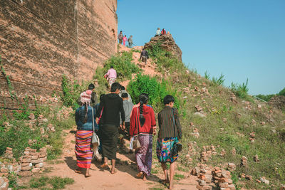 Rear view of people walking on road