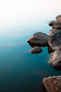 Rock formation in sea against sky