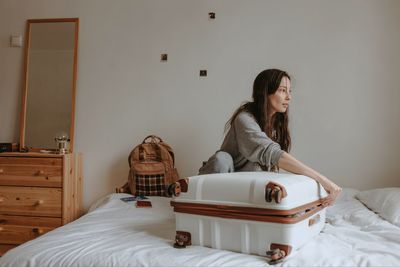 Woman with the baggage at home, preparing to flight