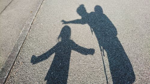 Shadow of woman with children on road