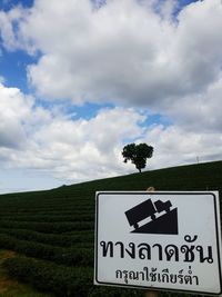 Information sign on landscape against cloudy sky