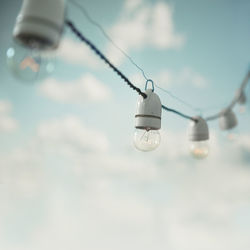 Low angle view of light bulb hanging on cable