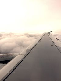 View of airplane flying against cloudy sky