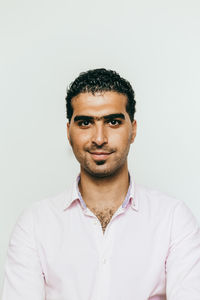 Portrait of smiling young man against white background