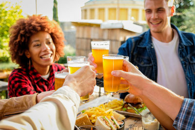 Cheerful friends having beer at restaurant