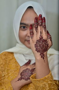 Portrait of young woman showing henna tattoo