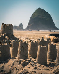 Close-up of sandcastles on beach against sky