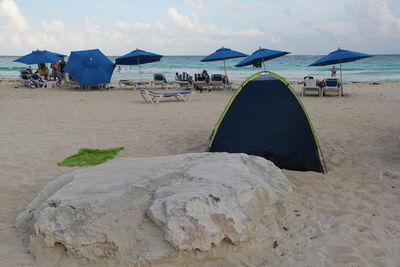 Group of people on enjoying on beach against sky