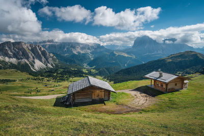 Houses on field by mountains against sky