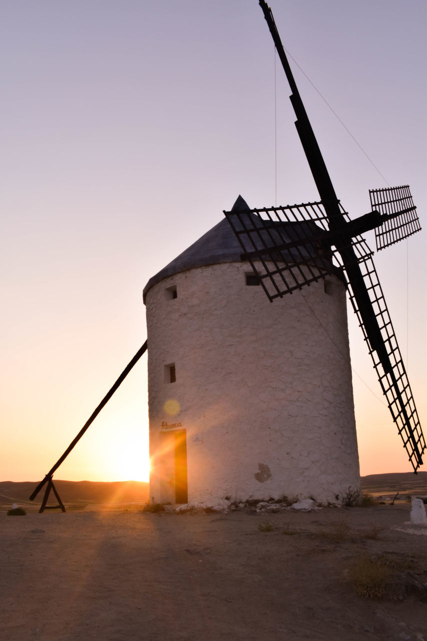 TRADITIONAL WINDMILL ON LANDSCAPE AGAINST SKY DURING SUNSET