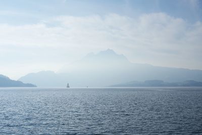 Scenic view of sea and mountains against sky