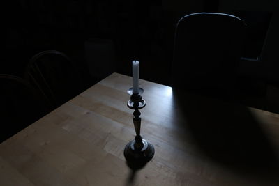 High angle view of candle on table in darkroom