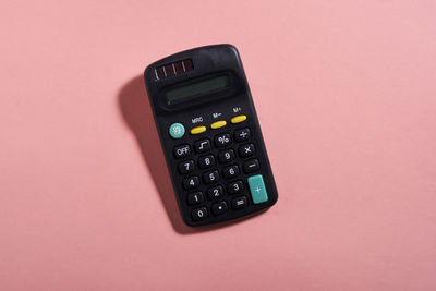 Close-up of calculator against pink background