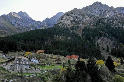 Scenic view of trees and buildings against mountains